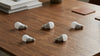 Five LED light bulbs are scattered across a wooden table, accompanied by stacked books and coasters, creating a minimalist and modern ambiance.